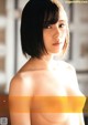 A naked asian woman with short black hair posing for a picture.