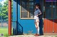 A woman standing in front of a blue building.