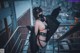 A woman in a black outfit is standing on a railing.