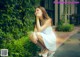 A woman in a white dress sitting on the ground.