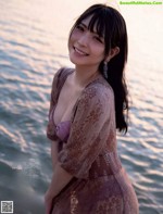 A woman in a purple dress standing in the water.