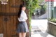 A young woman leaning against a wooden door.