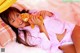 A woman laying on a bed holding a teddy bear.