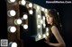 A woman standing in front of a lighted up sign.