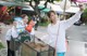 A woman taking a picture of another woman with a shopping cart.